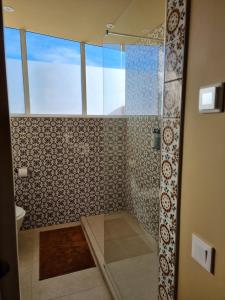 a bathroom with a shower with a glass door at Rooftop Guesthouse Alvor in Alvor