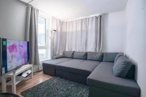a living room with a couch and a flat screen tv at Sea Apartment in Oslo