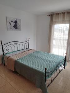 een slaapkamer met een bed in een kamer met een raam bij Ina House in Samos