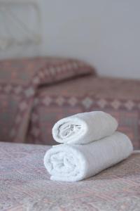 una pila de toallas sentadas encima de una cama en Tampu en Cachí