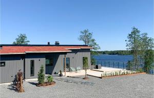 a house with a patio and a body of water at Lovely Home In Skillingaryd With Sauna in Skillingaryd