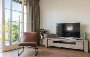 uma sala de estar com uma televisão e uma cadeira em Awesome Home In Stavoren With House Sea View em Stavoren