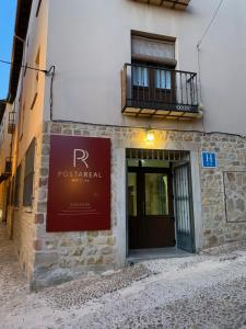 a sign on the side of a building with a door at Hotel Posta Real in Sigüenza
