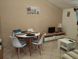 een woonkamer met een tafel en stoelen en een televisie bij Apartments Stjepic in Sukošan