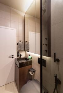 ein Bad mit einem Waschbecken und einem Spiegel in der Unterkunft High five apartments, Most City area in Dnipro