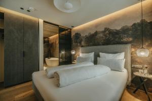 sypialnia z dużym białym łóżkiem i łazienką w obiekcie Black Eagle Luxury Appartements w Mayrhofen