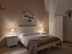 een slaapkamer met een bed met 2 nachtkastjes en 2 lampen bij Casal Sant'Angelo in Copertino