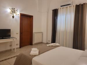 een slaapkamer met een groot bed en een televisie bij Casal Sant'Angelo in Copertino