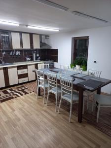 a kitchen with a dining room table and chairs at Cabana Antonia in Straja