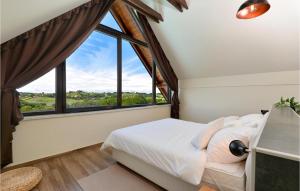 een slaapkamer met een bed en een groot raam bij Amazing Home In Selnica With Kitchen in Selnica