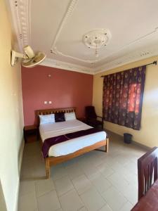 a bedroom with a bed and a red wall at Appart'hotel britannia in Yaoundé