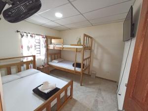 um quarto com uma cama e 2 beliches em Ekolores Hostal - PARQUE DEL CAFÉ - 313-468-08-41 em Montenegro