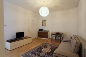 uma sala de estar com um sofá e uma televisão em Casa Nostra - Moderne Stadtwohnung mit Balkon em Viena