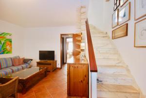 uma sala de estar com um sofá e uma escada em Carlos House - Baleal beach, Sunny balcony, Shared pool no Baleal