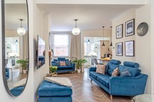 a living room with blue couches and a mirror at The Hideaway in Chester