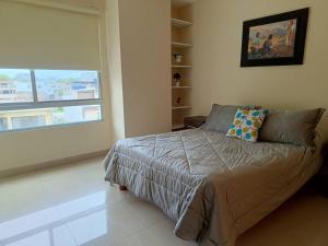 1 dormitorio con cama y ventana grande en Suite de Una Habitación con Vista al Mar y Piscina en Manta, en Manta