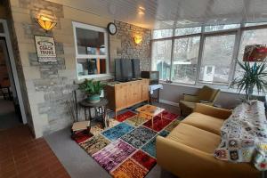 a living room with a couch and a tv at Quirky mid century themed holiday home in Shepton Mallet