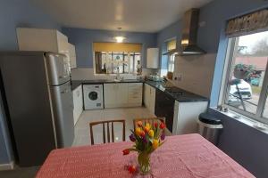a kitchen with a table with a vase of flowers on it at Quirky mid century themed holiday home in Shepton Mallet +22 photos
