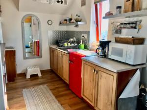 a kitchen with a red refrigerator and wooden cabinets at Kiscsillag Vendégház in Budapest