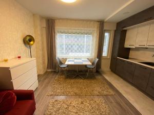 a living room with a table and a kitchen at Lovely Studio in Kallio in Helsinki