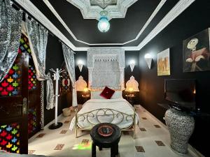 una camera con letto e TV di Riad Mogador a Meknès