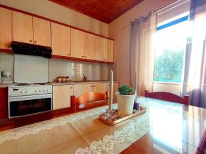 a kitchen with a table and a stove and a window at Affordable vintage apartment near Fiscardo & Assos in Fiskardho