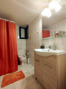 a bathroom with a sink and a red shower curtain at Affordable vintage apartment near Fiscardo & Assos in Fiskardho