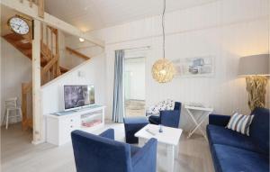 オルペニッツにある3 Bedroom Stunning Home In Ostseeresort Olpenitzのリビングルーム(青い椅子、テレビ付)