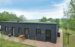 een zwart tiny house met een terras bij Nice Home In Knebel With House Sea View in Knebel