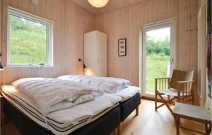 een groot bed in een kamer met een raam bij Nice Home In Knebel With House Sea View in Knebel