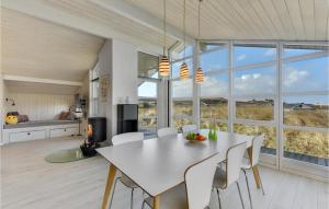 a kitchen and dining room with a white table and chairs at Pet Friendly Home In Hvide Sande With Wifi in Havrvig