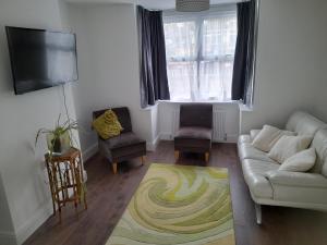 ein Wohnzimmer mit einem Sofa und einem TV in der Unterkunft Salmestone Stay in Margate