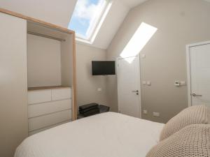 a bedroom with a bed and a skylight at Lilac Cottage in Lymington