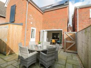 a patio with a table and chairs and a brick building at Lilac Cottage in Lymington