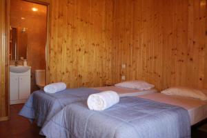 two beds in a room with wood paneled walls at Rocaplana Club de Campo in Vilarrodona