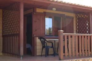 un porche de una casa con una mesa y una silla en Rocaplana Club de Campo en Vilarrodona