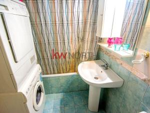 ein Badezimmer mit einem Waschbecken und einer Waschmaschine in der Unterkunft Fully Furnished Cozy Stay in Thérmi