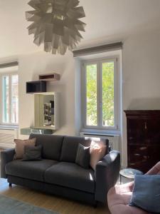 uma sala de estar com um sofá e duas janelas em Trastevere Design Apartment em Roma