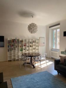 ローマにあるTrastevere Design Apartmentのリビングルーム(テーブル、椅子、シャンデリア付)