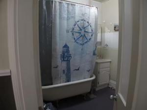 a bathroom with a bath tub with a shower curtain at Wolseley the heart of the city ! in Winnipeg
