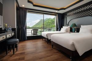 a hotel room with two beds and a large window at Doris Cruise in Ha Long