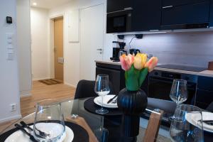 a table with a vase of tulips in a kitchen at Otava in Rovaniemi