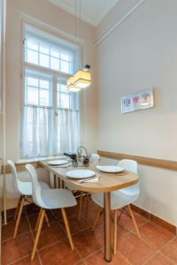 a dining room with a wooden table and chairs at City Center Apartment Debrecen in Debrecen