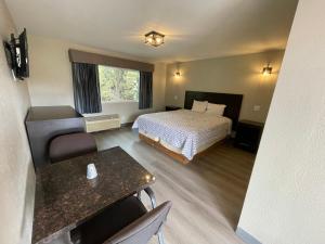 um quarto de hotel com uma cama e uma mesa em VILLA INN em Anaheim