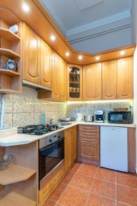 a kitchen with wooden cabinets and white appliances at City Center Apartment Debrecen in Debrecen