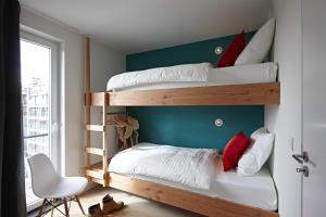 sypialnia z 2 łóżkami piętrowymi i krzesłem w obiekcie Kustappartementen w mieście Blankenberge