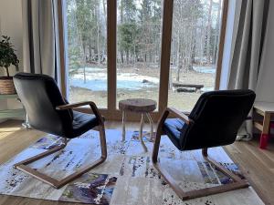 two chairs and a table in a room with a window at Chalet Deer Trail Tatranská Lomnica in Vysoke Tatry - Tatranska Lomnica.