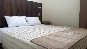 a bed with a blanket on top of it at Casa Blanca Puerto López in Puerto López