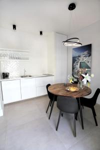 cocina con mesa de madera y sillas negras en Junior Unicorn Suite, en Atenas