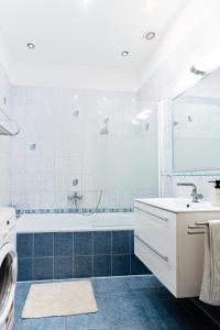 La salle de bains blanche est pourvue d'une baignoire et d'un lavabo. dans l'établissement City Center Apartment Debrecen, à Debrecen